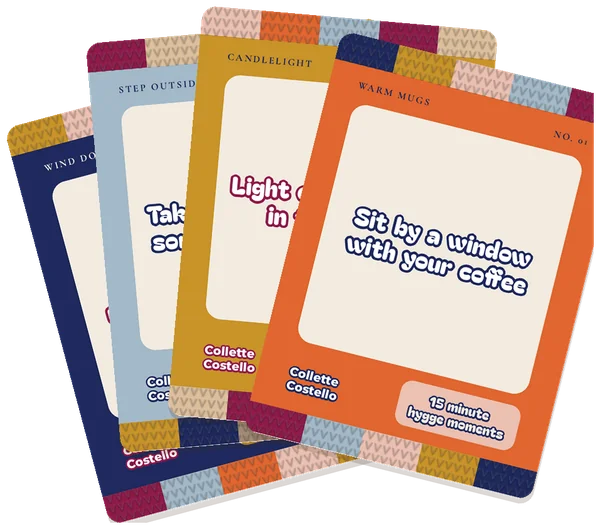 Four 15 minute hygge moments cards fanned out: Wind Down, Step Outside, Candlelight and Warm Mugs